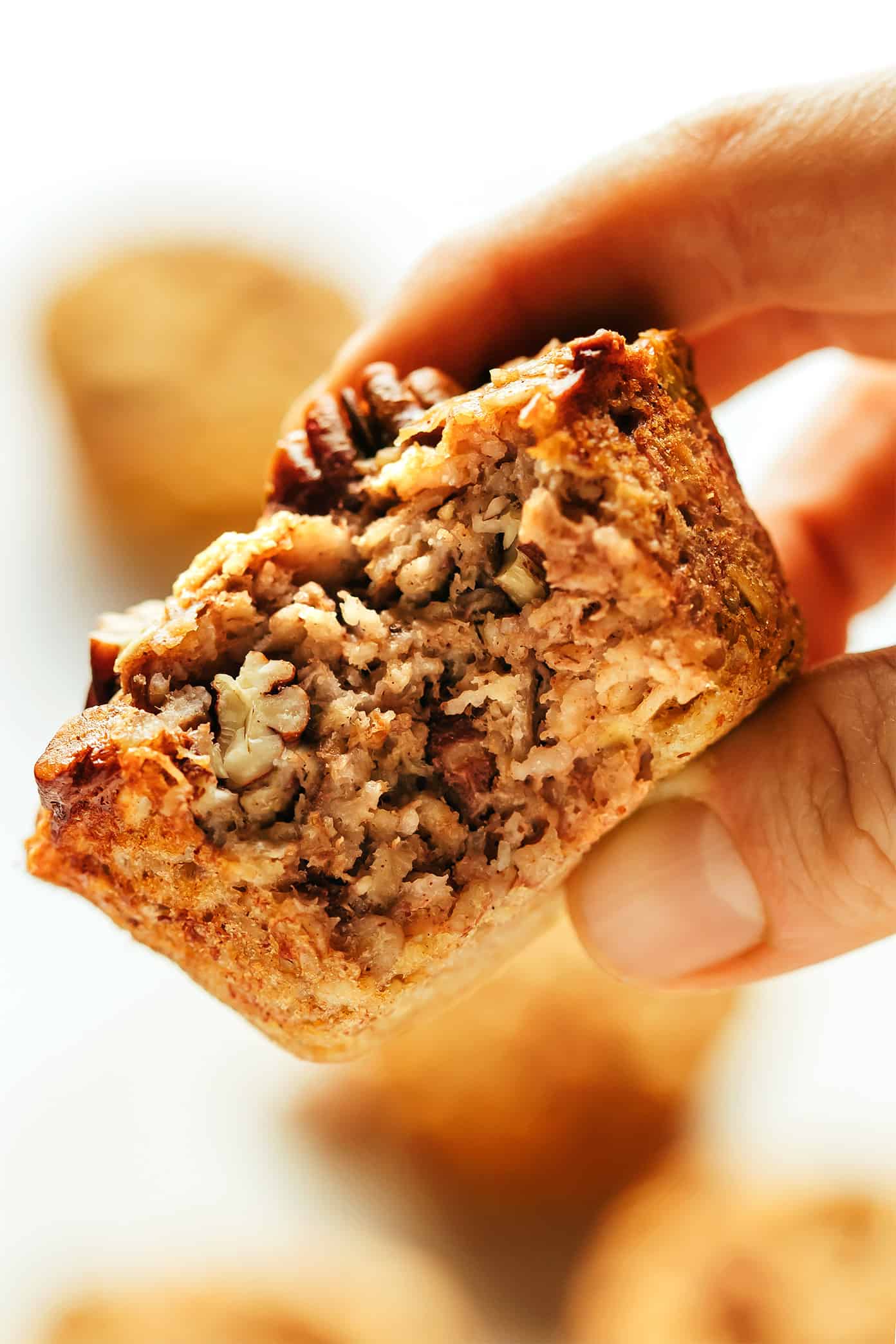 This banana baked oatmeal cups recipe is easy to make, naturally gluten-free, and perfect for healthy grab-and-go breakfast and snacks. Feel free to add in nuts, chocolate chips, raisins or coconut if you'd like too. And these oat cups freeze well if you'd like to do some meal prep for make ahead breakfasts. | gimmesomeoven.com Banana Baked Oatmeal Cup Closeup