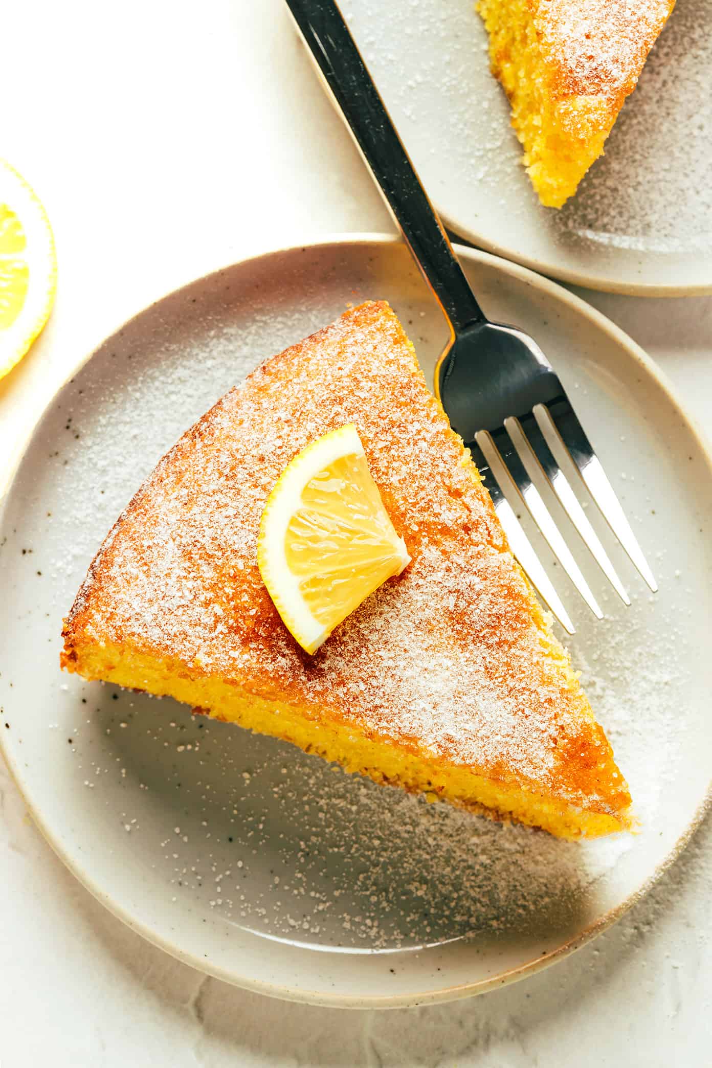 This citrus olive oil cake recipe is easy to make in one bowl, naturally gluten-free and dairy-free, lightly sweetened, and made with the loveliest hints of fresh orange and lemon. Perfect for dessert, snacking or even breakfast and always so delicious. Serve on its own or with whipped cream, ice cream or fruit and enjoy! | gimmesomeoven.com Slice of Citrus Olive Oil Cake with Fork