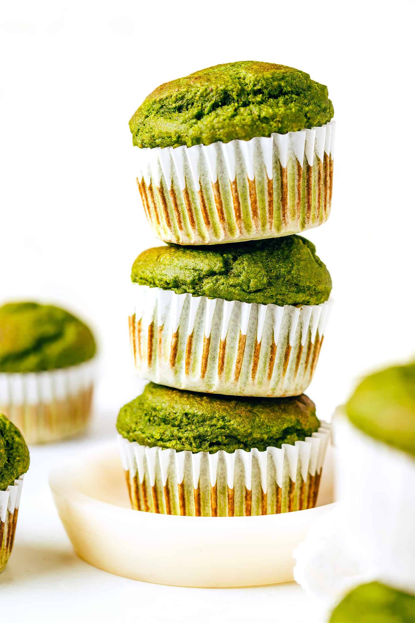 These blender spinach banana muffins are kid-approved, naturally sweetened and gluten-free, and so delicious! | gimmesomeoven.com green muffins in a stack