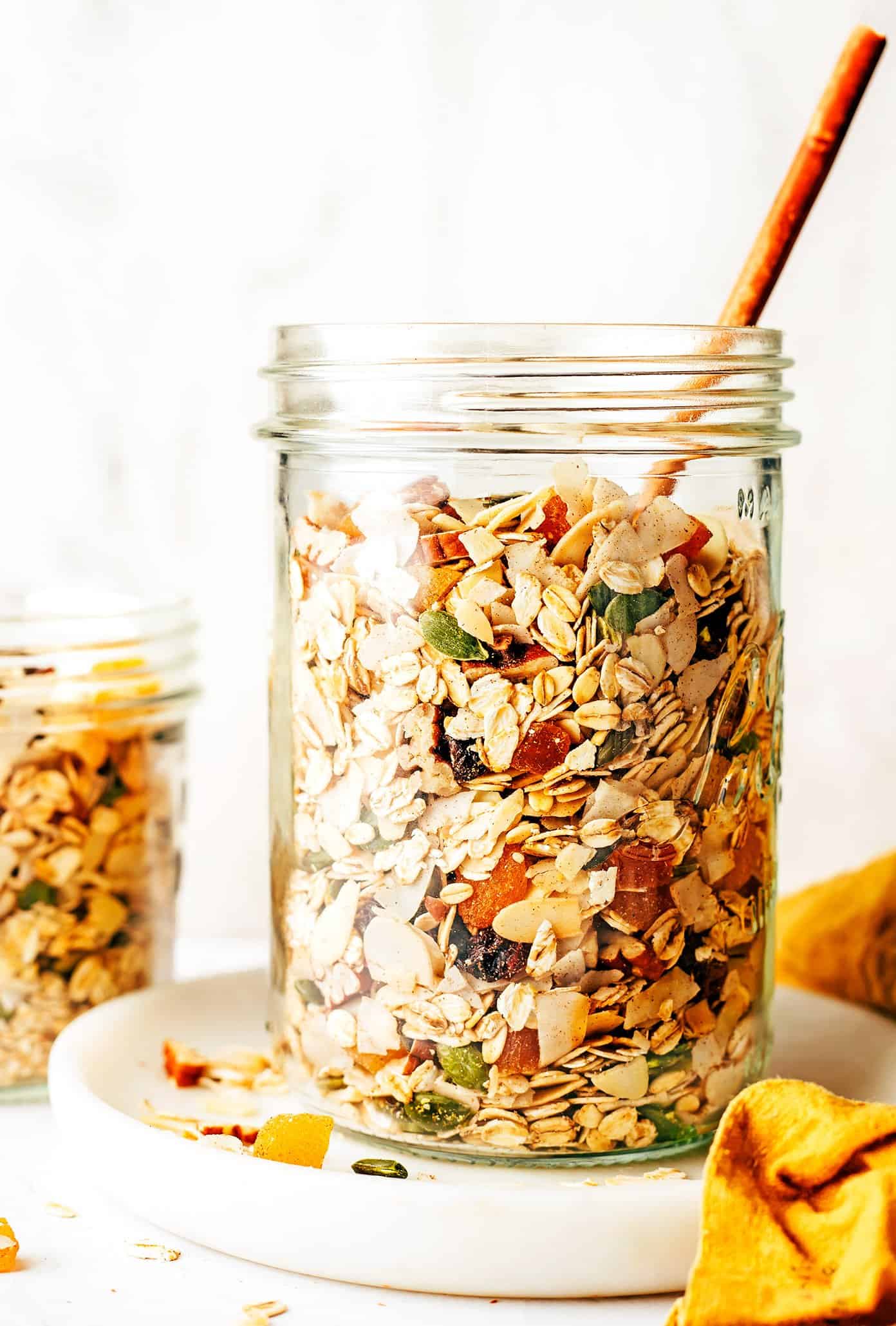This delicious homemade muesli recipe is easy to make and customize with your favorite blend of oats, nuts, seeds, dried fruit, coconut (optional) and spices. Serve with hot or cold milk, prep "overnight oats"-style, layer as a parfait with Greek yogurt, or however you love best. Always such a great healthy and easy breakfast! | gimmesomeoven.com Jar of homemade muesli