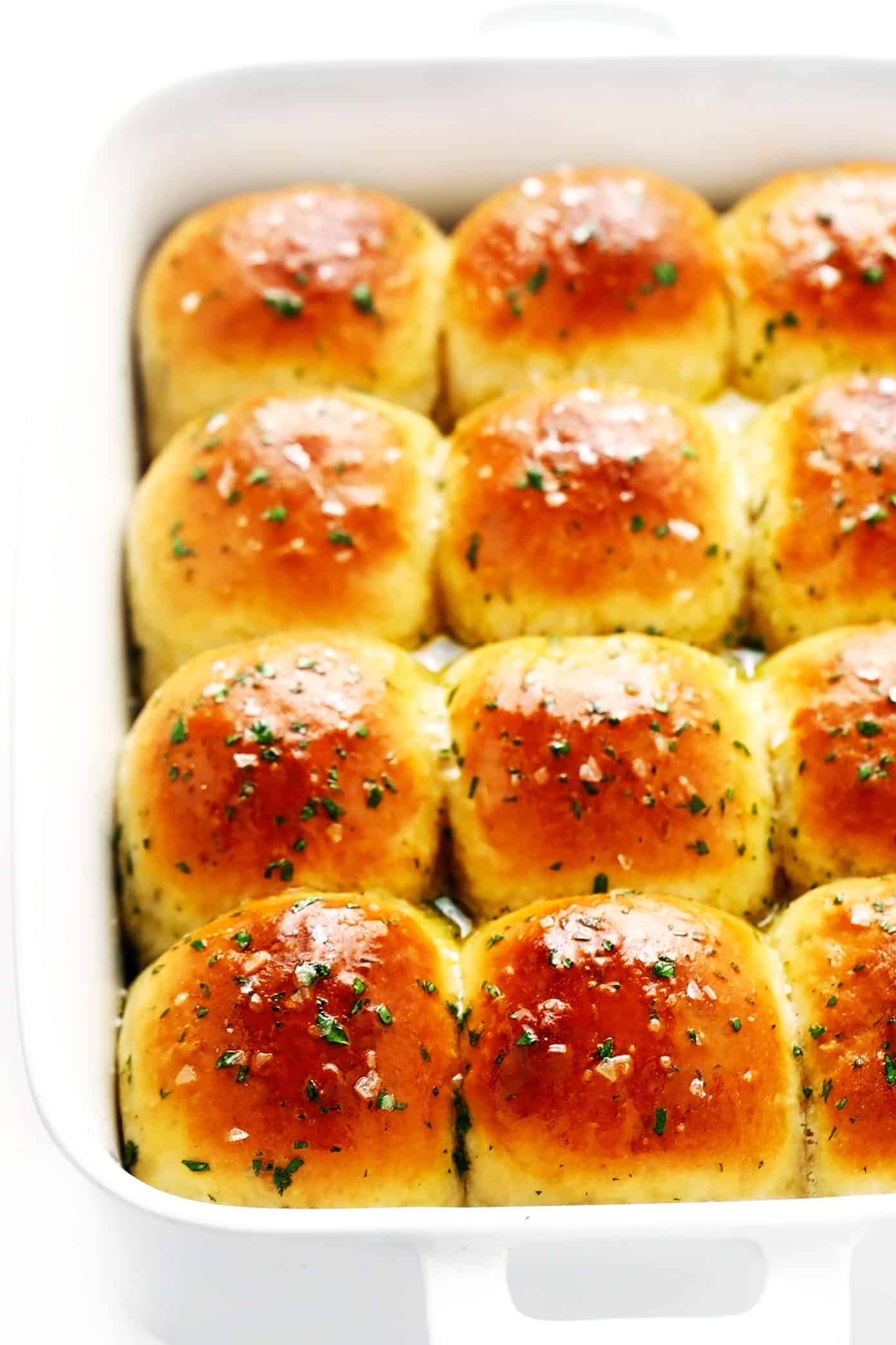This rosemary garlic dinner rolls recipe is perfectly soft and fluffy, easy to make with or without a stand mixer, brushed with garlic herb butter and sprinkled with flaky sea salt, and ready to go in about one hour! Always a fantastic side dish for holidays like Thanksgiving, or the perfect easy bread recipe for weeknight dinners too. Vegan option included. | gimmesomeoven.com One Hour Rosemary Garlic Dinner Rolls