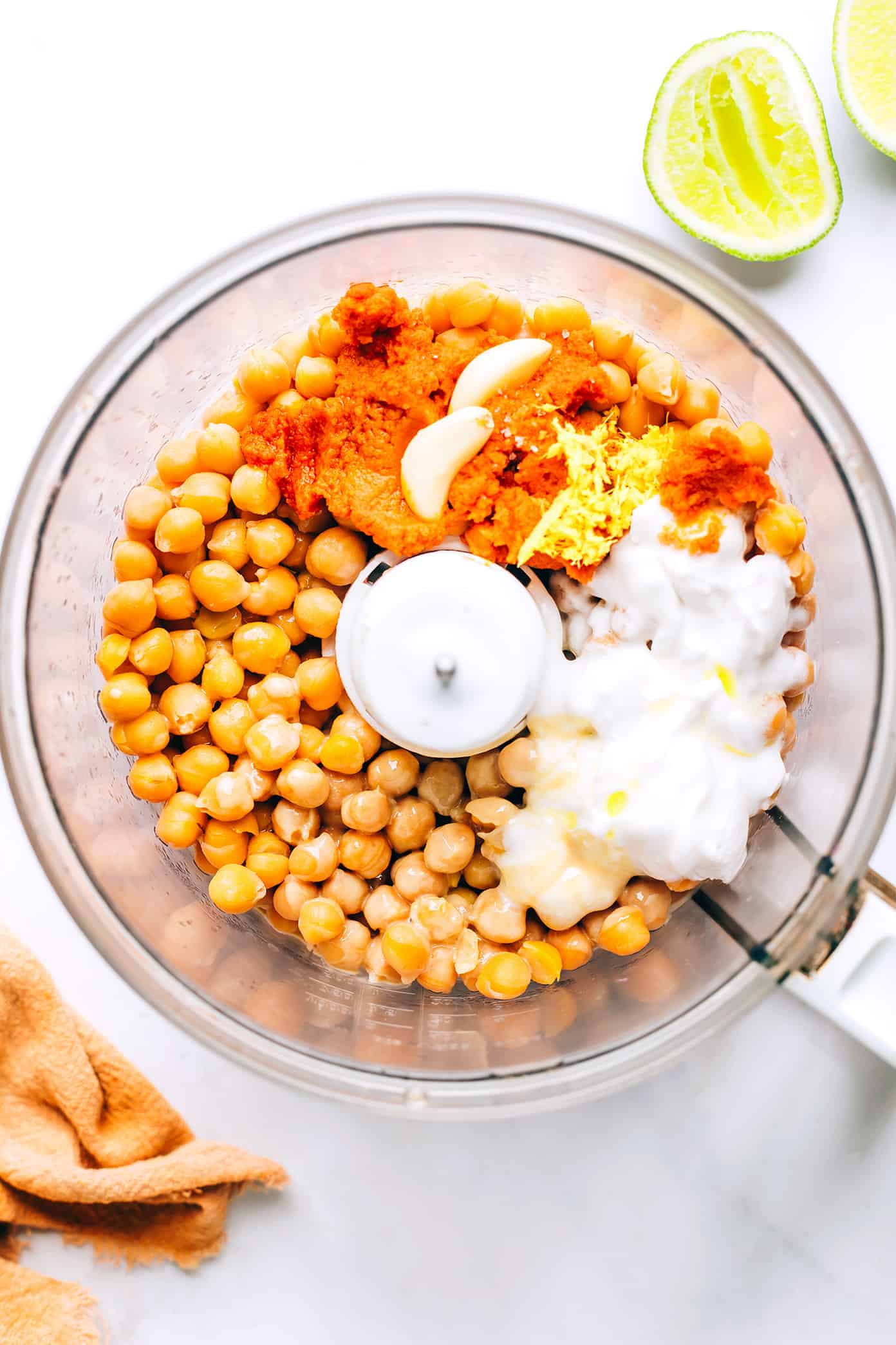 This Thai-inspired red curry hummus recipe is quick and easy to make in just 10 minutes with chickpeas, tahini, coconut milk, curry paste, ginger and garlic. Serve it up as a dip with cruditรฉs and naan, or use it as a spread on burgers or wraps. Such a great easy appetizer! | gimmesomeoven.com Red Curry Hummus in Food Processor