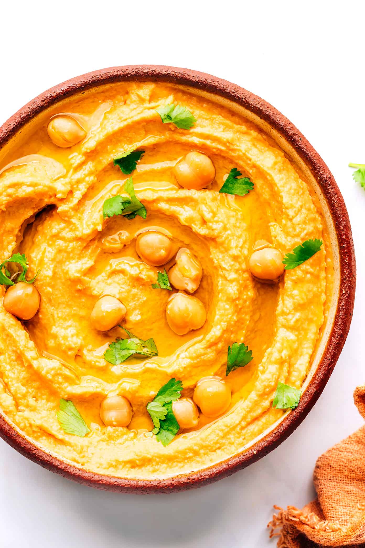 This Thai-inspired red curry hummus recipe is quick and easy to make in just 10 minutes with chickpeas, tahini, coconut milk, curry paste, ginger and garlic. Serve it up as a dip with cruditรฉs and naan, or use it as a spread on burgers or wraps. Such a great easy appetizer! | gimmesomeoven.com Thai Red Curry Hummus in Bowl with Chickpeas
