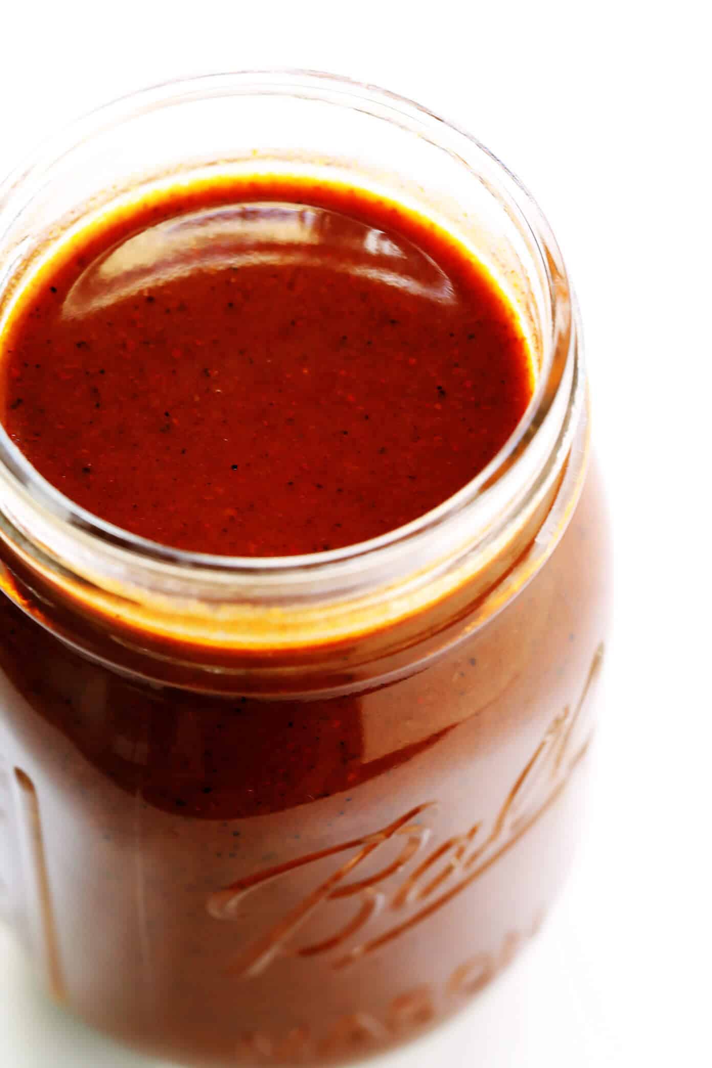 This homemade red enchilada sauce recipe is easy to make in just 20 minutes, and full of the most delicious Southwestern and Mexican chili flavors. Perfect to use in enchiladas, soups, nachos, tacos and more! (Vegatarian / Vegan / Gluten-Free) | gimmesomeoven.com Jar of red enchilada sauce
